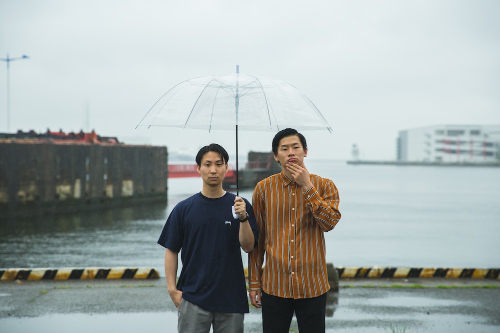 Young ethnic men with umbrella