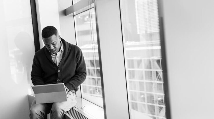 Grayscale Photo of Man Using Laptop