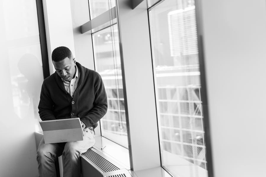 Grayscale Photo of Man Using Laptop