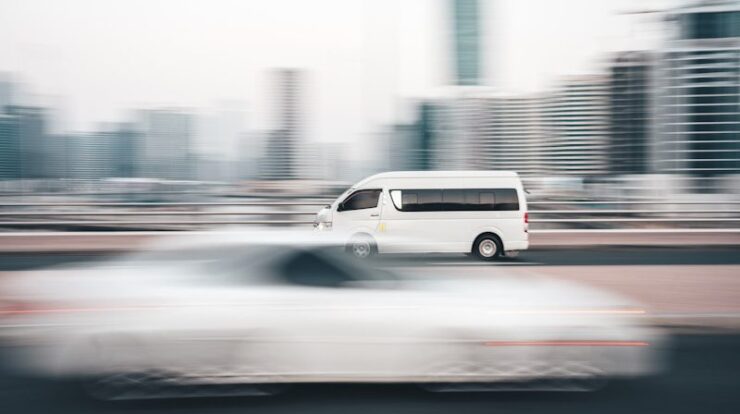 a white van driving down a street next to tall buildings