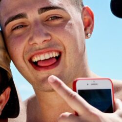 man holding iPhone in between two men