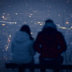 man and woman sitting on bench during night time