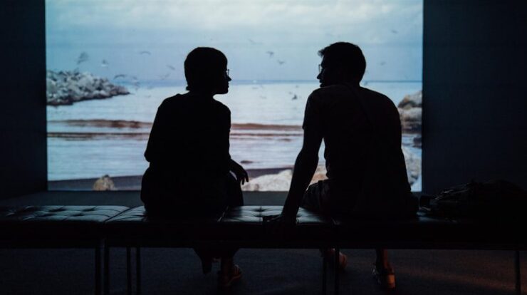 silhouette of man and woman sitting on ottoman