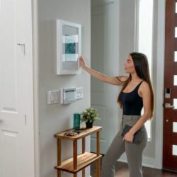 a woman standing in front of a wall mounted light switch