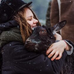 woman cuddling goat