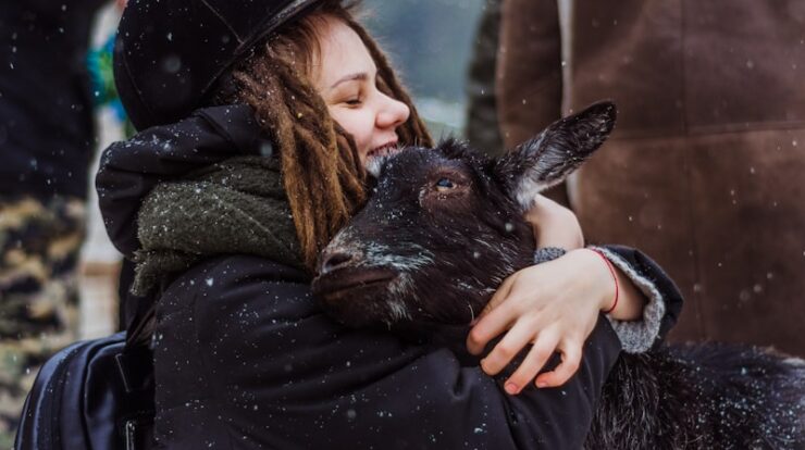 woman cuddling goat