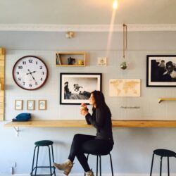 woman sitting on stall near wall mounted desk