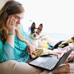 woman in teal long sleeve shirt holding black laptop computer