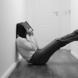 woman in white long sleeve shirt and black pants sitting on floor