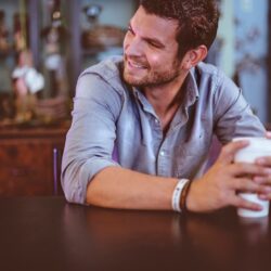 man holding cup on table